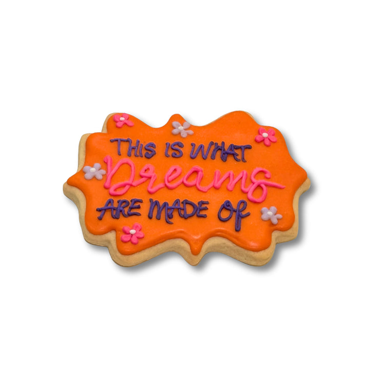 Lizzie McGuire cookie with orange icing and floral accents.