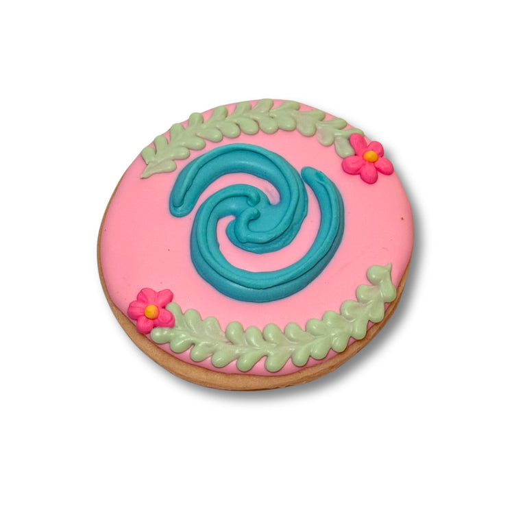 Moana cookie with pink icing and a blue spiral design
