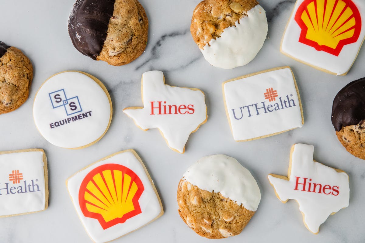 Assorted corporate logo cookies and chocolate-dipped cookies.