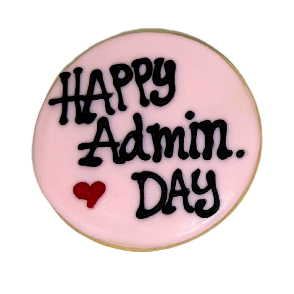Round cookie with pink icing and Happy Admin Day text.