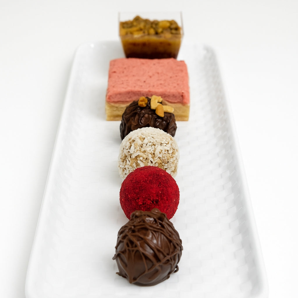 Raspberry Sweet Tarts and assorted truffles on a white tray.