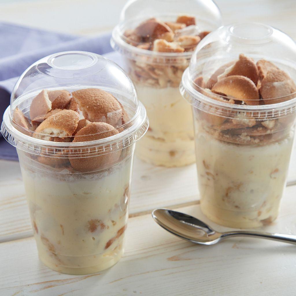 Banana pudding in clear plastic cups with wafer toppings.