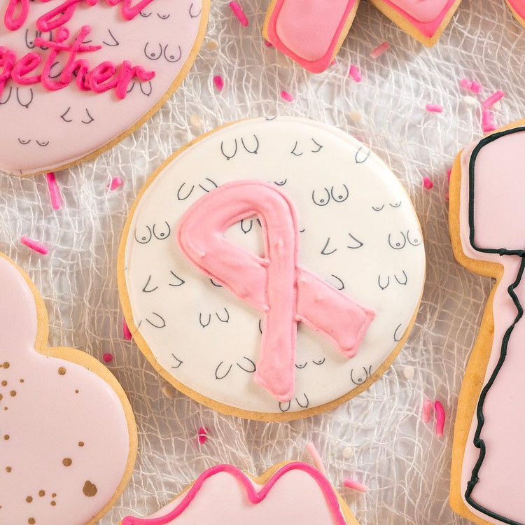 Assorted Breast Cancer Awareness cookies with pink ribbon icing.