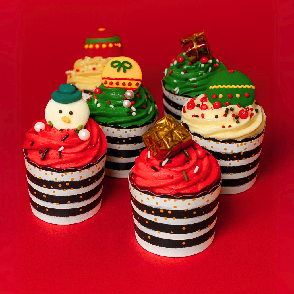 Christmas cupcakes with festive toppers in striped liners.