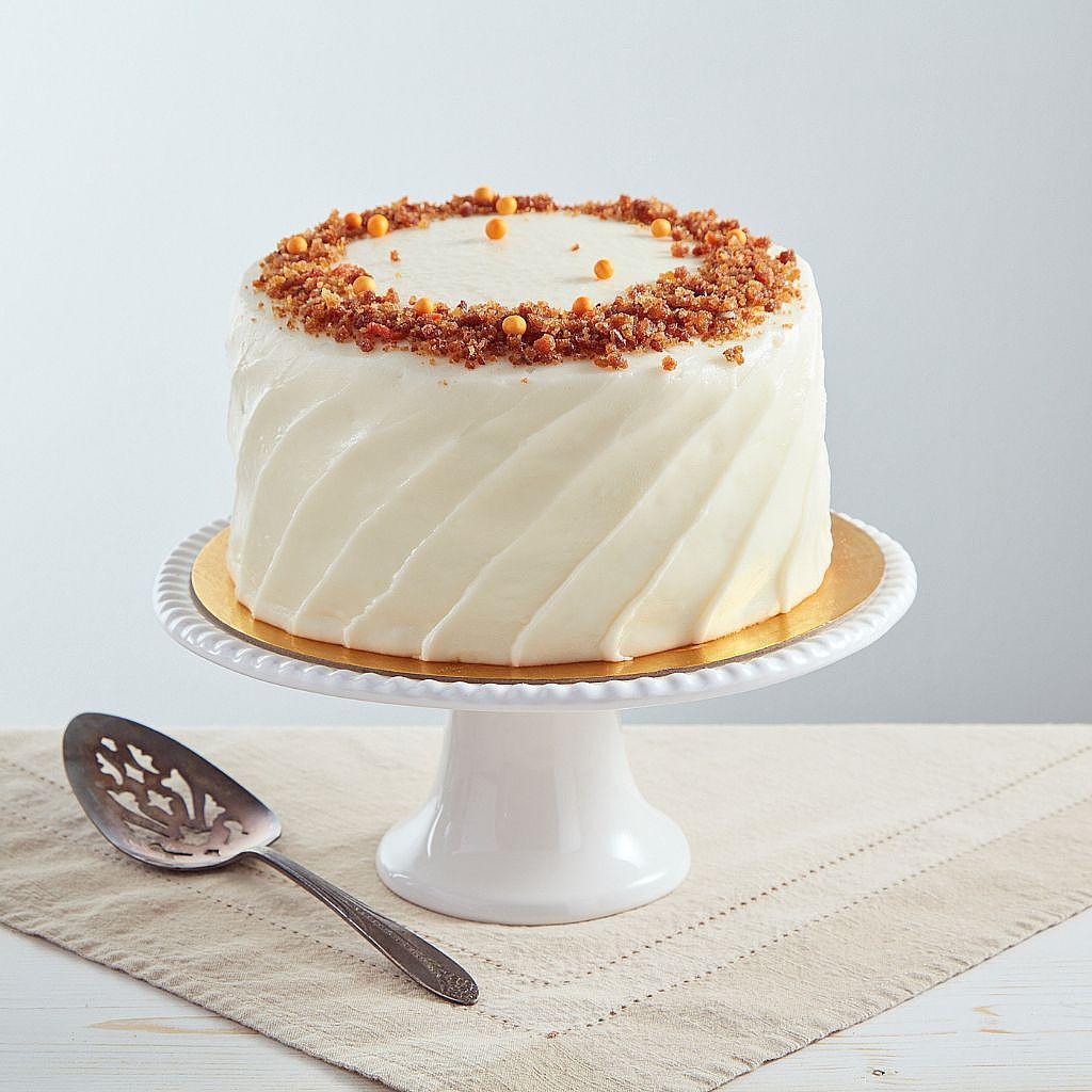 6-inch carrot cake with white frosting on a pedestal stand