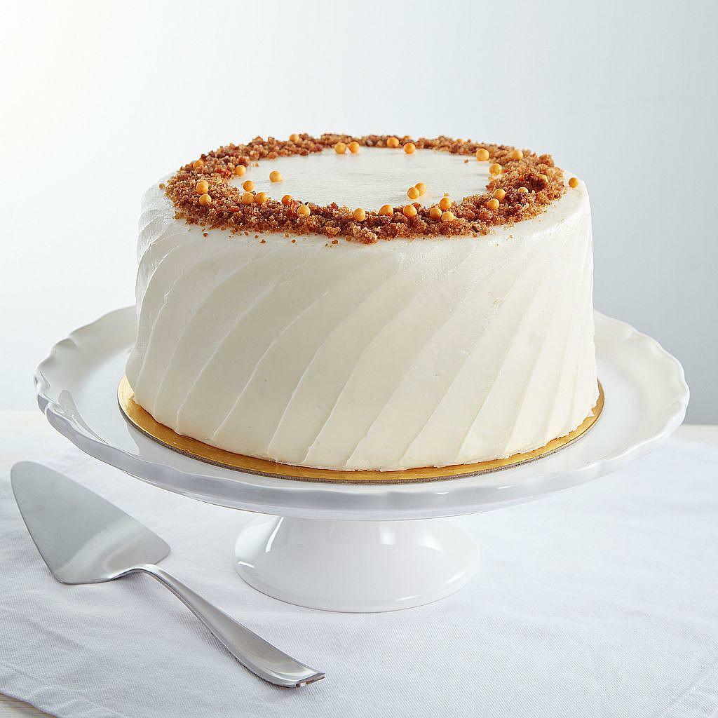 9-inch carrot cake with white frosting on a pedestal stand