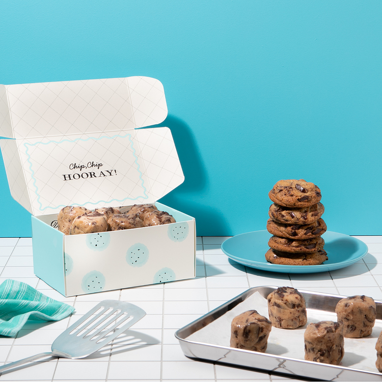 Chocolate Chunk Dough by DG in a box with baked cookies on a plate.