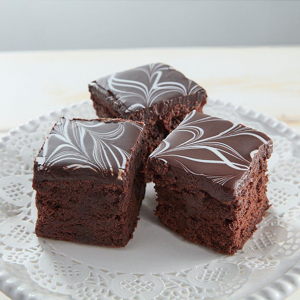 Three Chocolate Decadence GF bars with white icing swirls.