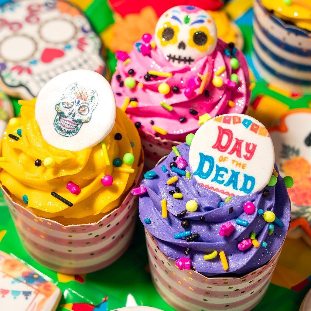 Day of the Dead cupcakes with colorful frosting and toppers.