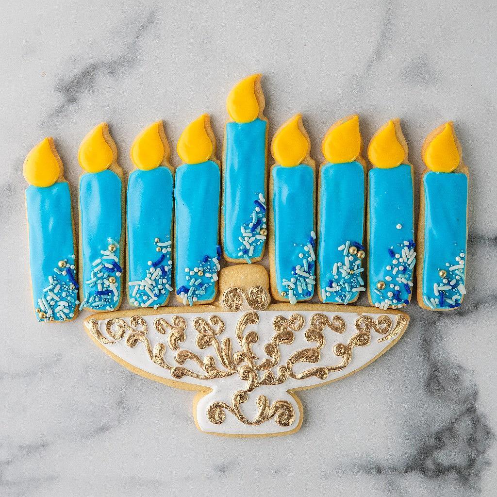 Menorah cookie decorated with blue icing and gold accents