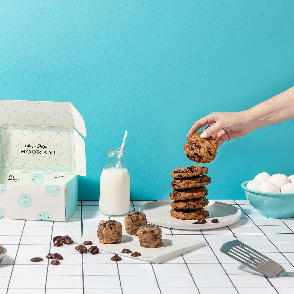 Chocolate Chunk Dough by DG with a stack of baked cookies