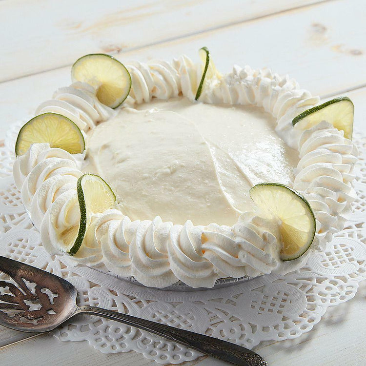 Double Decker Key Lime Pie with whipped cream and lime slices.