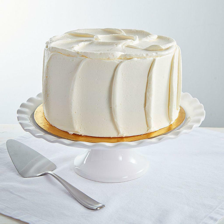 9-inch French Vanilla Cake with smooth white frosting on a stand.