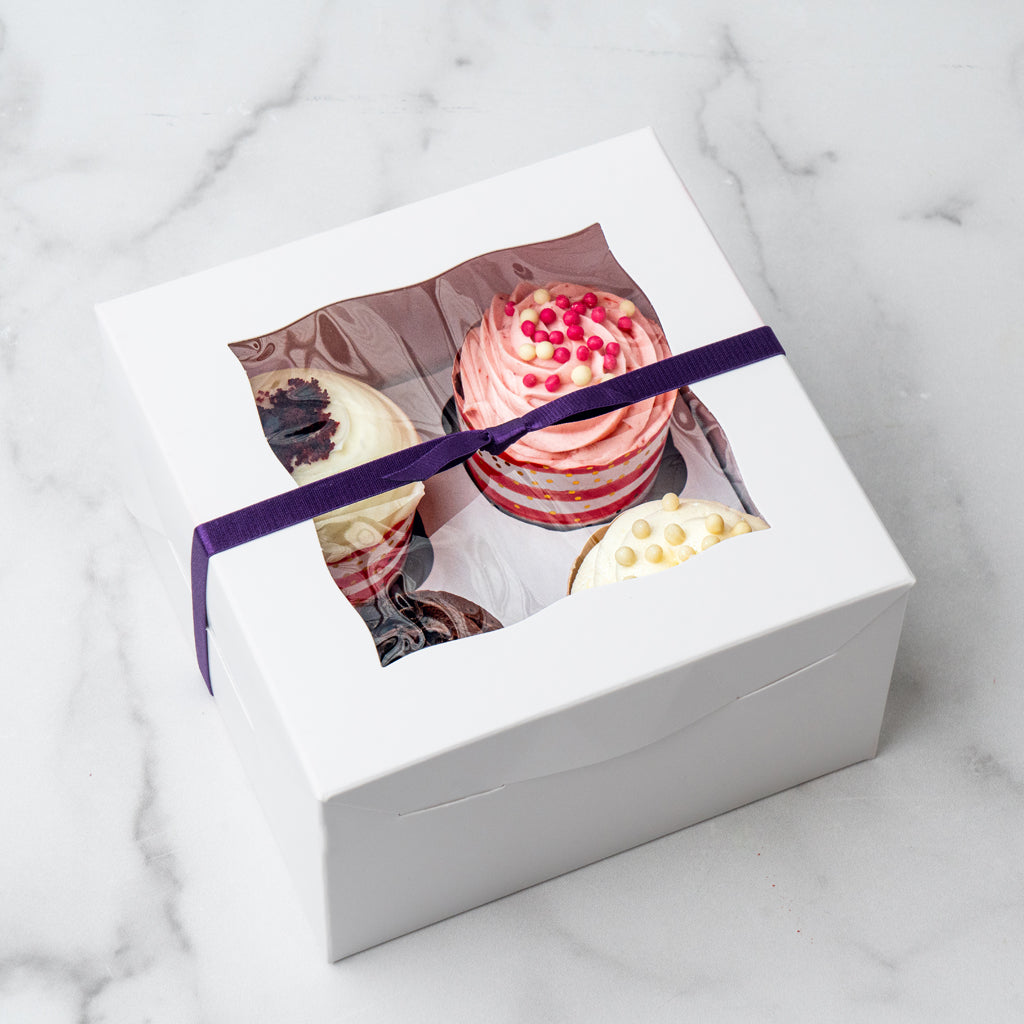 4-pack cupcake gift box with a purple ribbon on marble surface