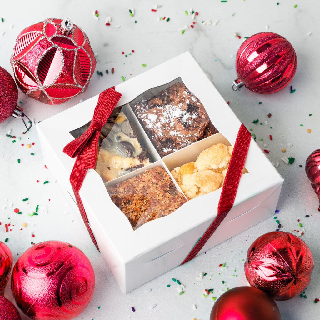 Bar cookie gift box with red ribbon and holiday ornaments.