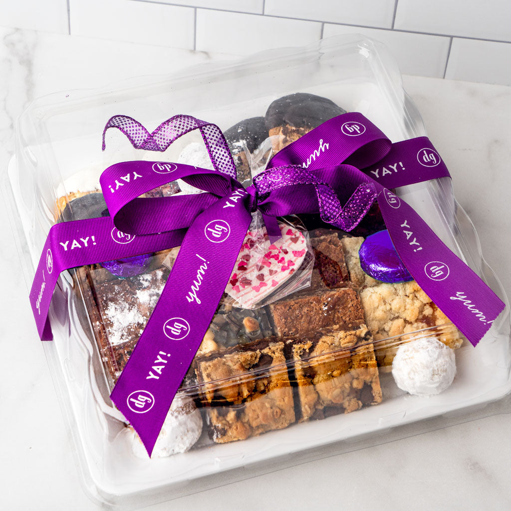 Cookie Extravaganza assortment in a clear box with purple ribbon