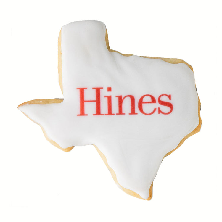 Texas-shaped cookie with white icing and red logo text.