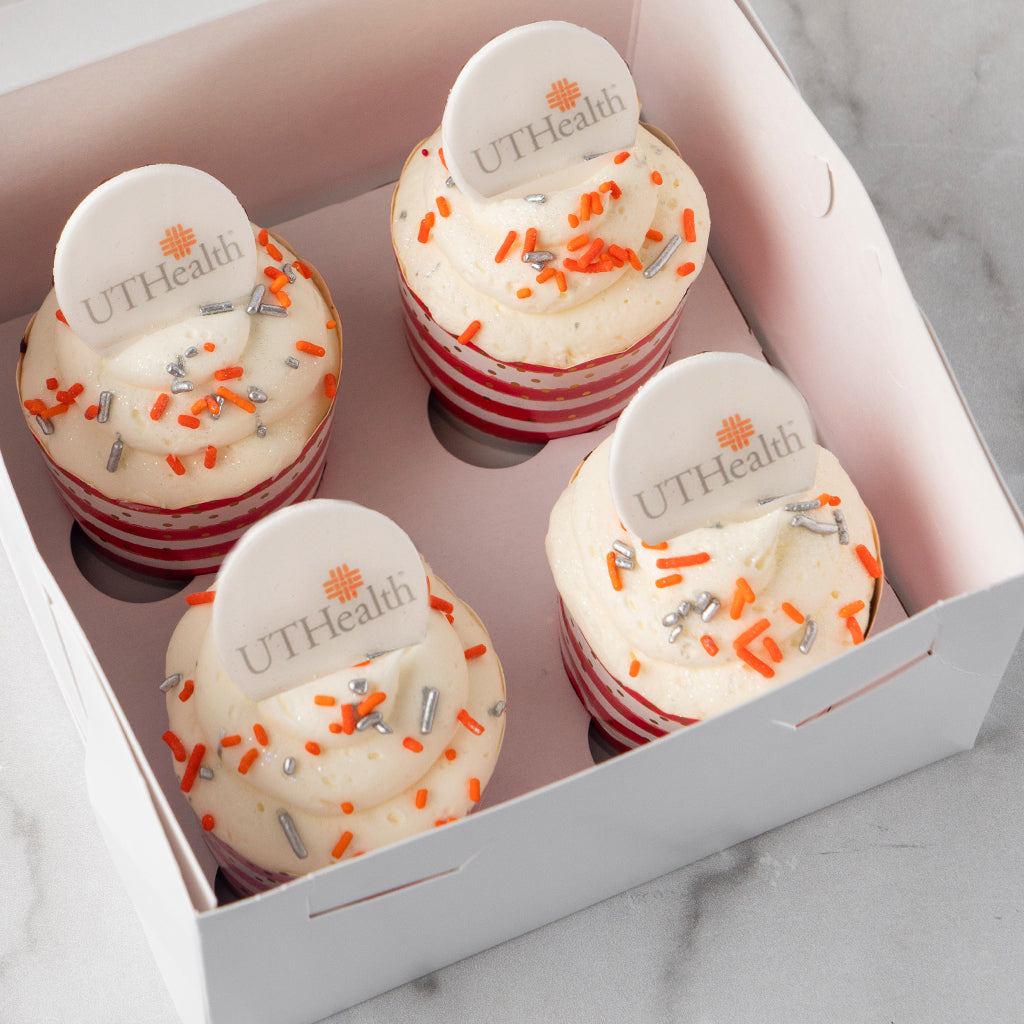 Four Photo & Logo Cupcakes with orange and silver sprinkles in a box.