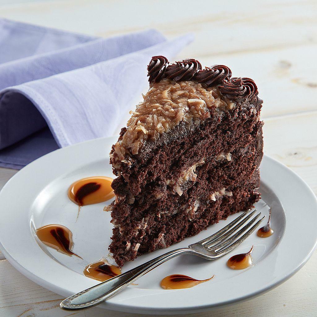 German Chocolate Cake slice with coconut pecan frosting on a plate.