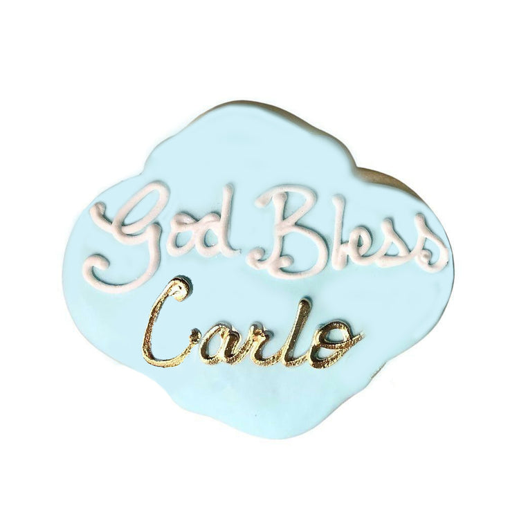 Light blue God Bless plaque cookie with gold name lettering.