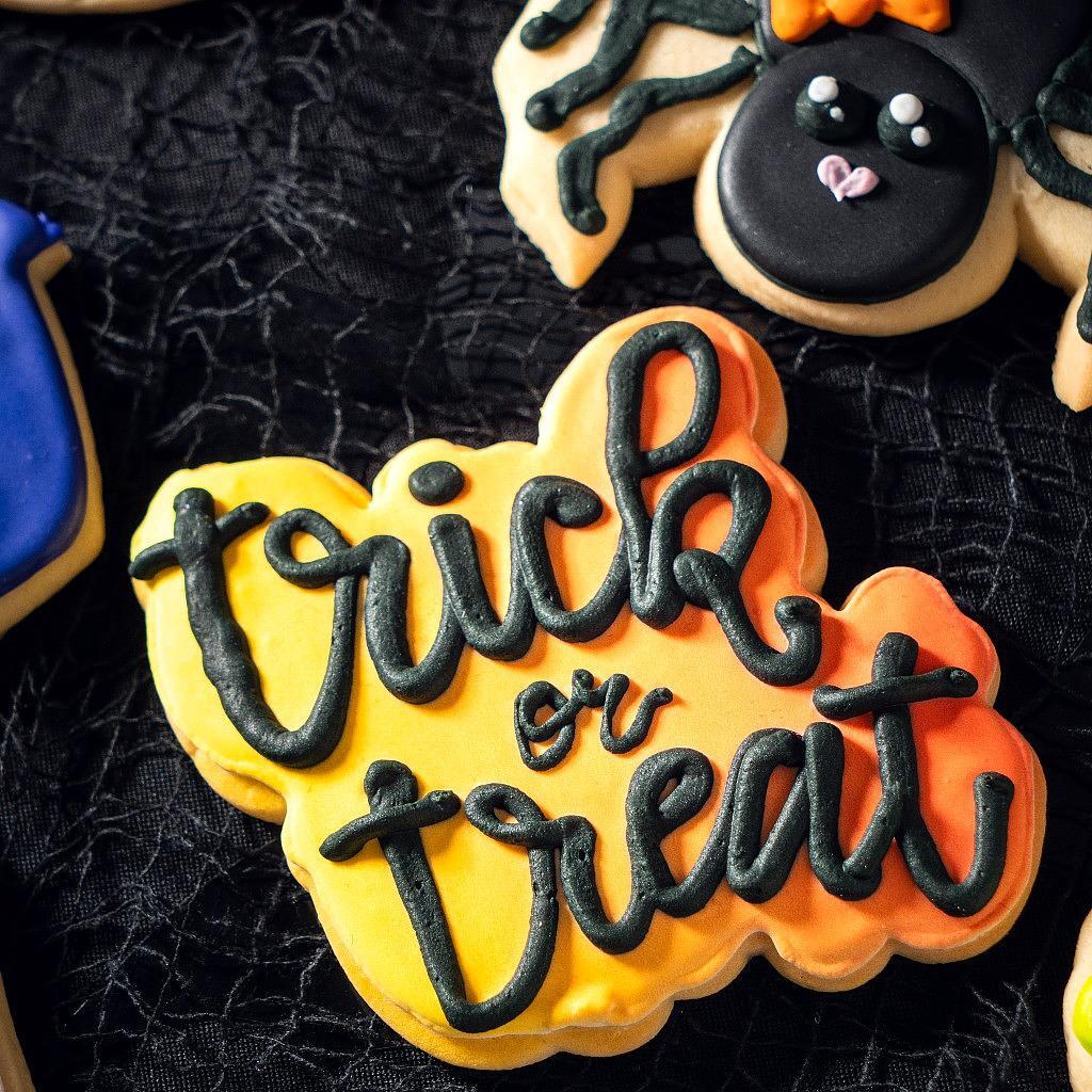 Assorted Halloween cookies with black Trick or Treat icing.