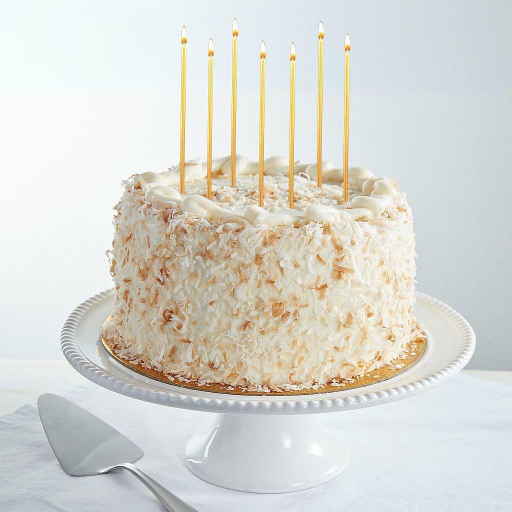 9-inch Italian cream cake topped with lit gold candles.