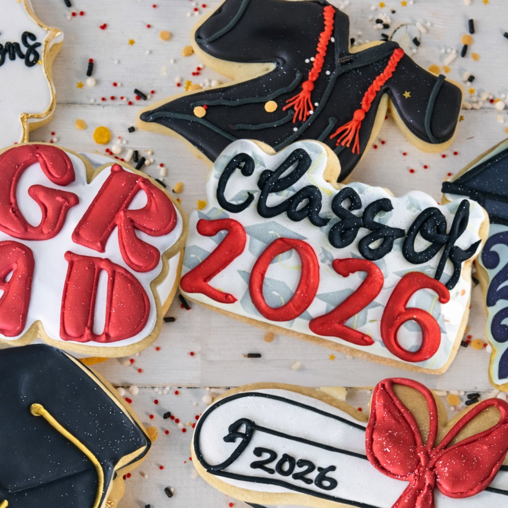 Assorted graduation cookies with red and black icing designs.