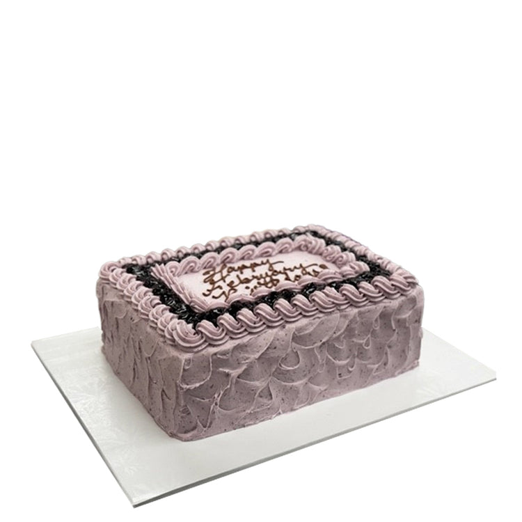 Lemon blueberry sheet cake with purple frosting and piping.
