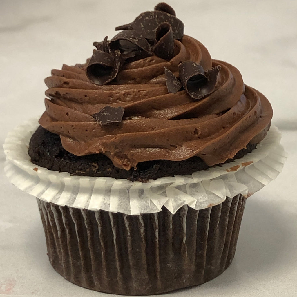 Mini chocolate cupcake with frosting and chocolate shavings.
