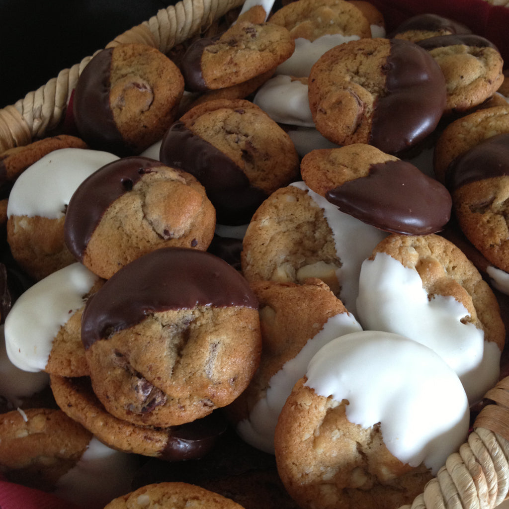 Miniature cookies dipped in dark and white chocolate in a basket.
