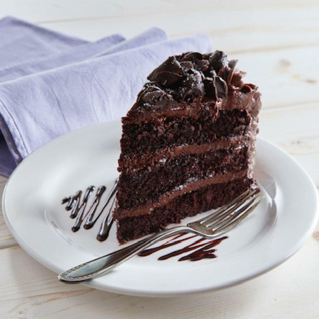 Slice of 9-inch Mom's Chocolate Cake on a white plate with a fork.