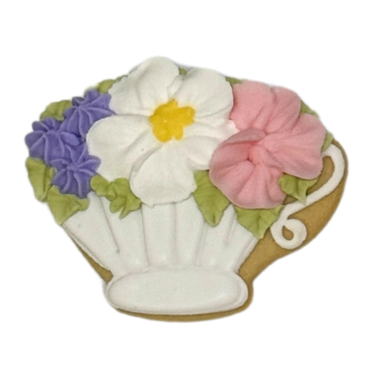 Mother's Day cookie shaped like a teacup with floral icing.