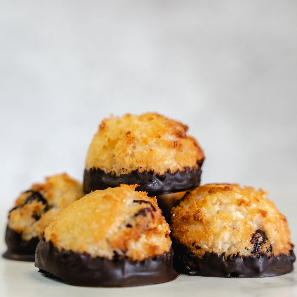 Chocolate-dipped coconut cranberry macaroons in a stack.