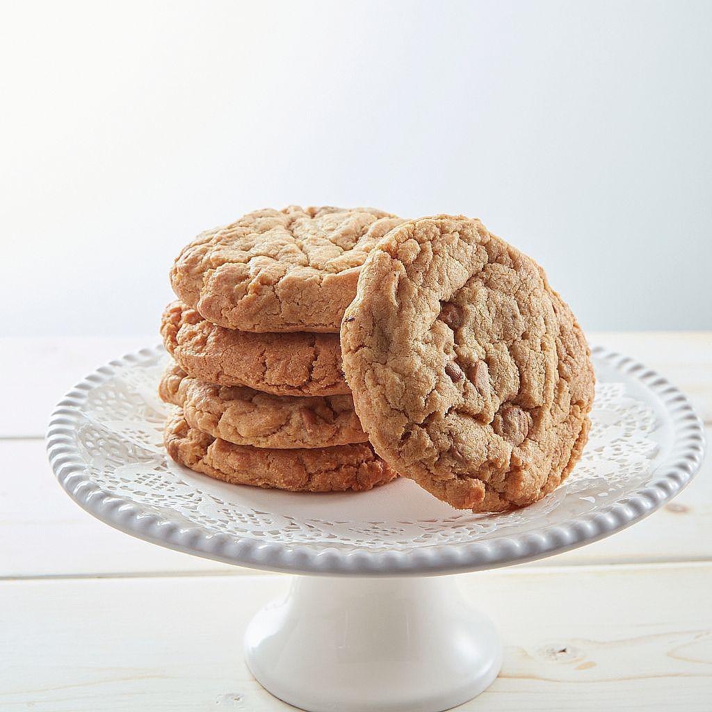 Stack of peanut butter cookies on a white cake stand