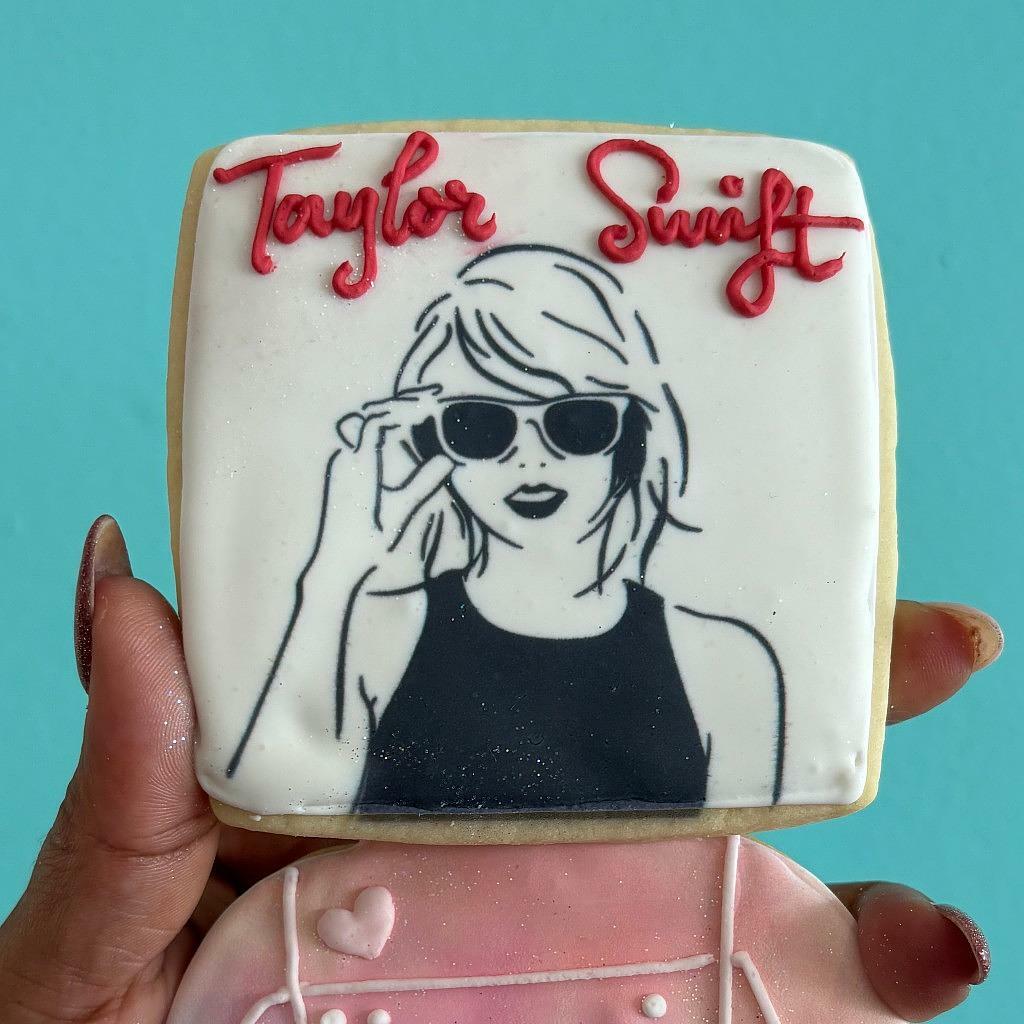 Taylor Swift portrait cookie with red icing lettering