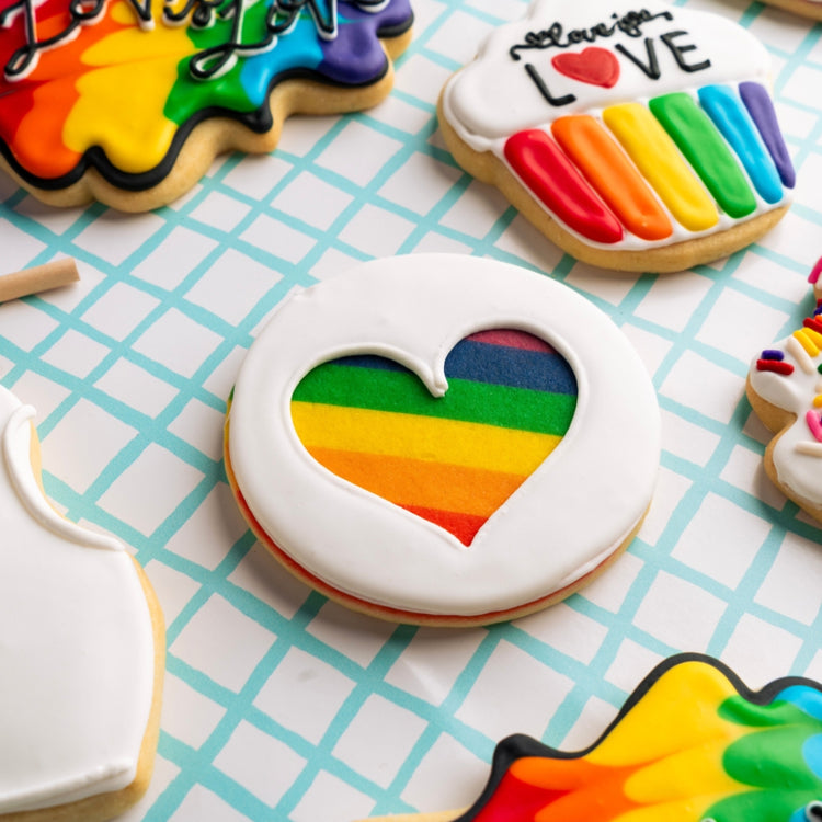 Assorted Pride cookies with colorful heart icing designs.