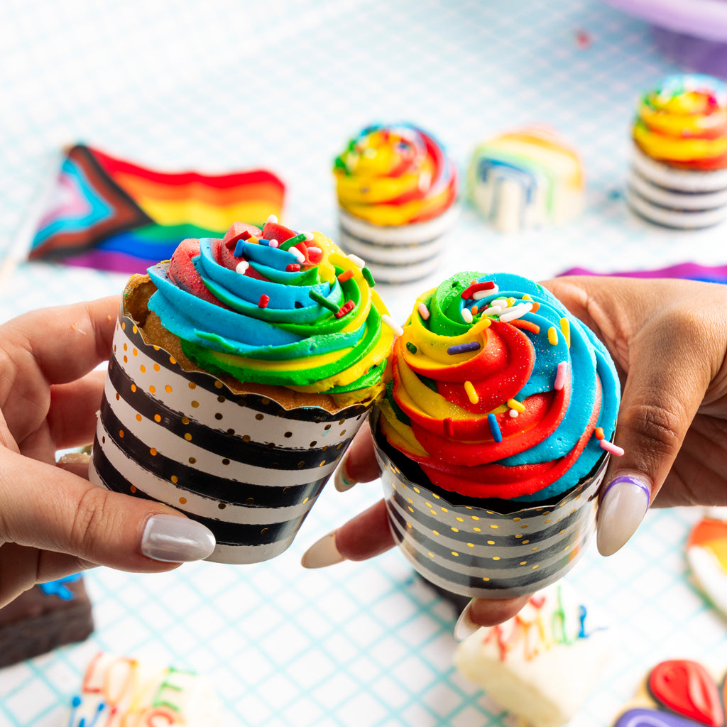 Pride cupcakes with rainbow frosting in striped paper liners