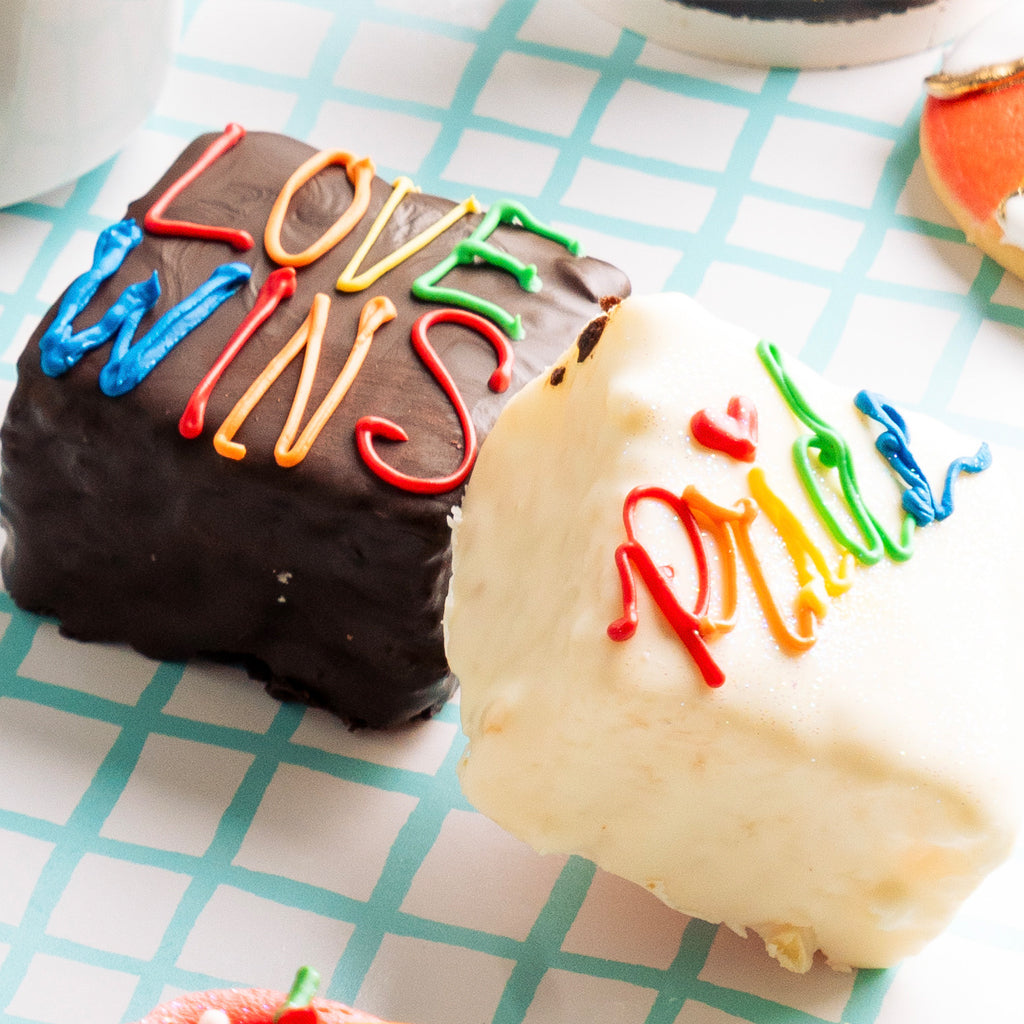 Pride Petit Fours with colorful icing on a grid background