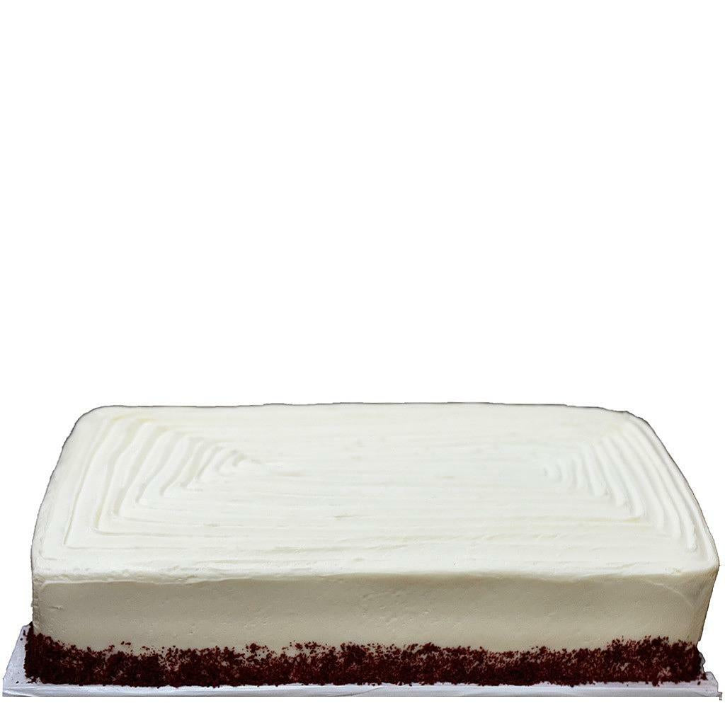 Red velvet sheet cake with smooth white frosting and red crumbs.