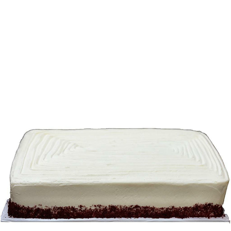 Red velvet sheet cake with smooth white frosting and red crumbs.