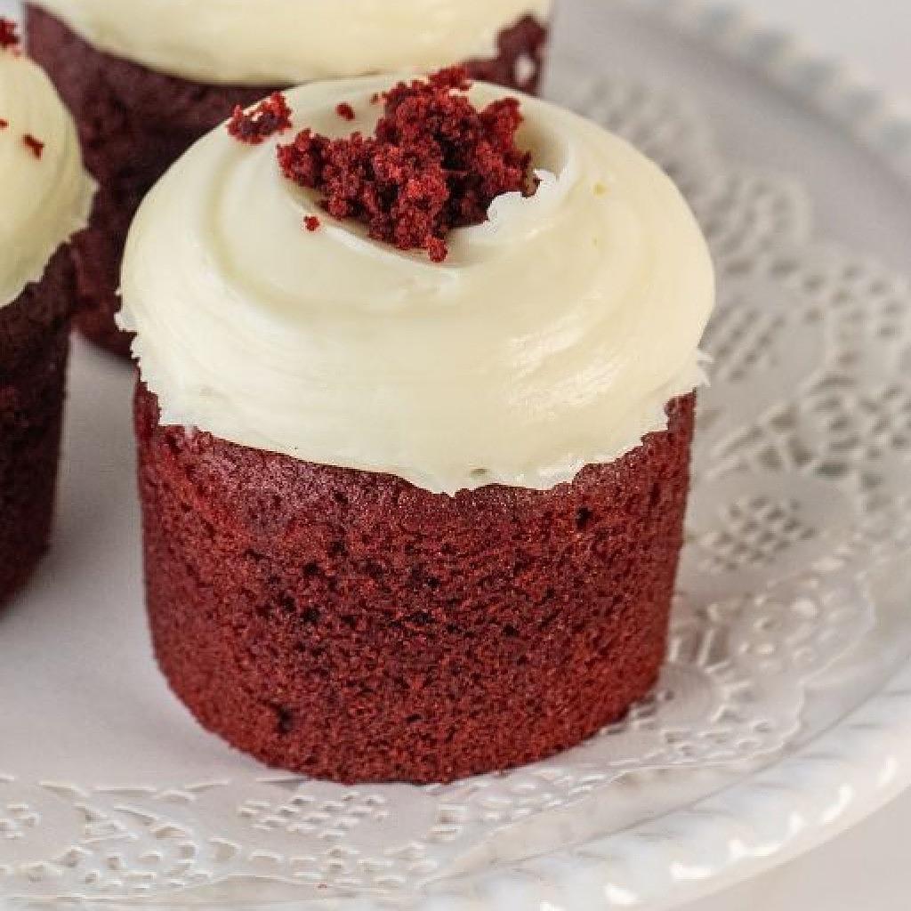Assorted red velvet cupcakes with white cream frosting