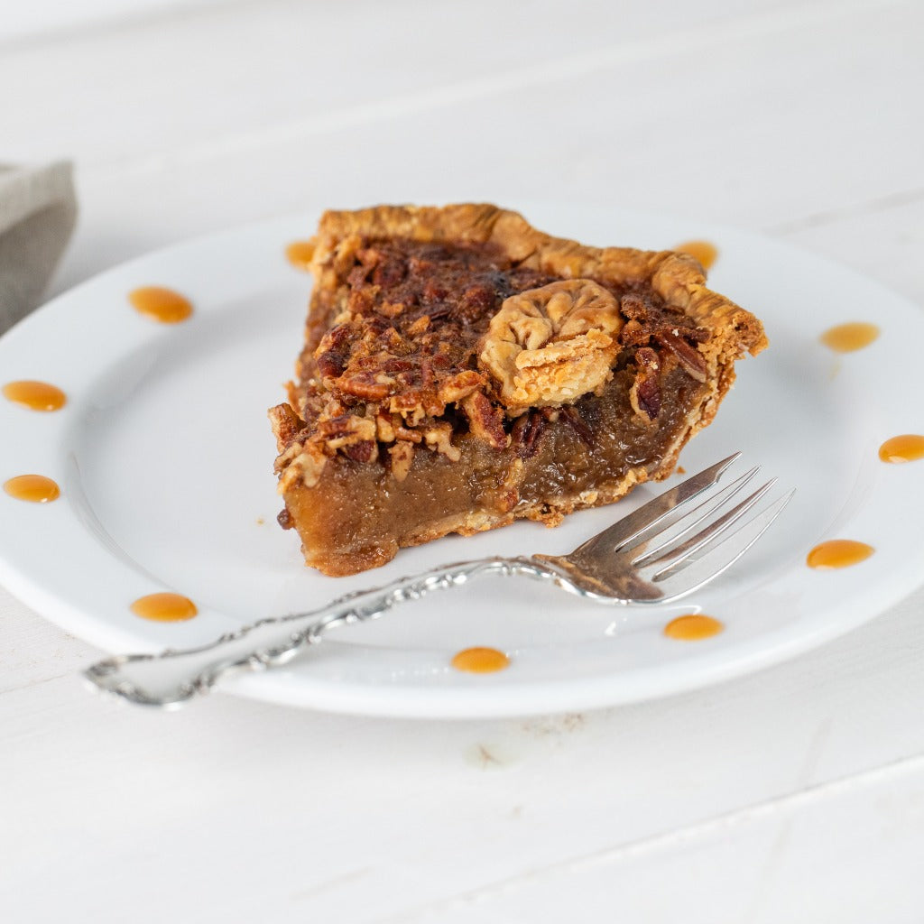 Southern Pecan Pie slice on a plate with caramel drizzle