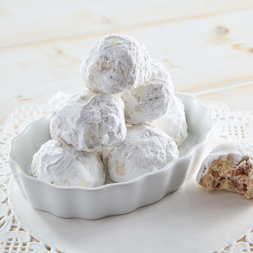 Sand Tarts dusted in powdered sugar in a white dish