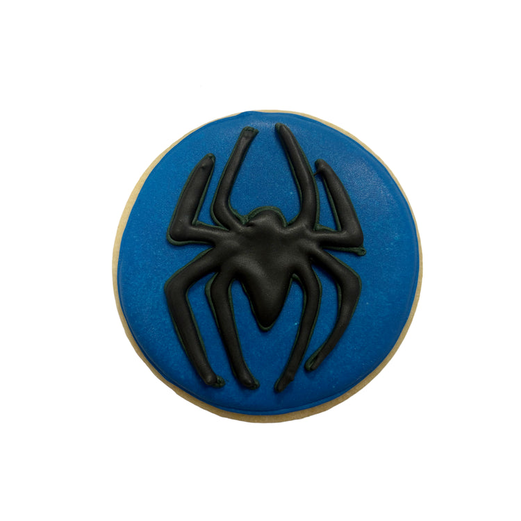 Spiderman cookie with a black spider on a blue background.