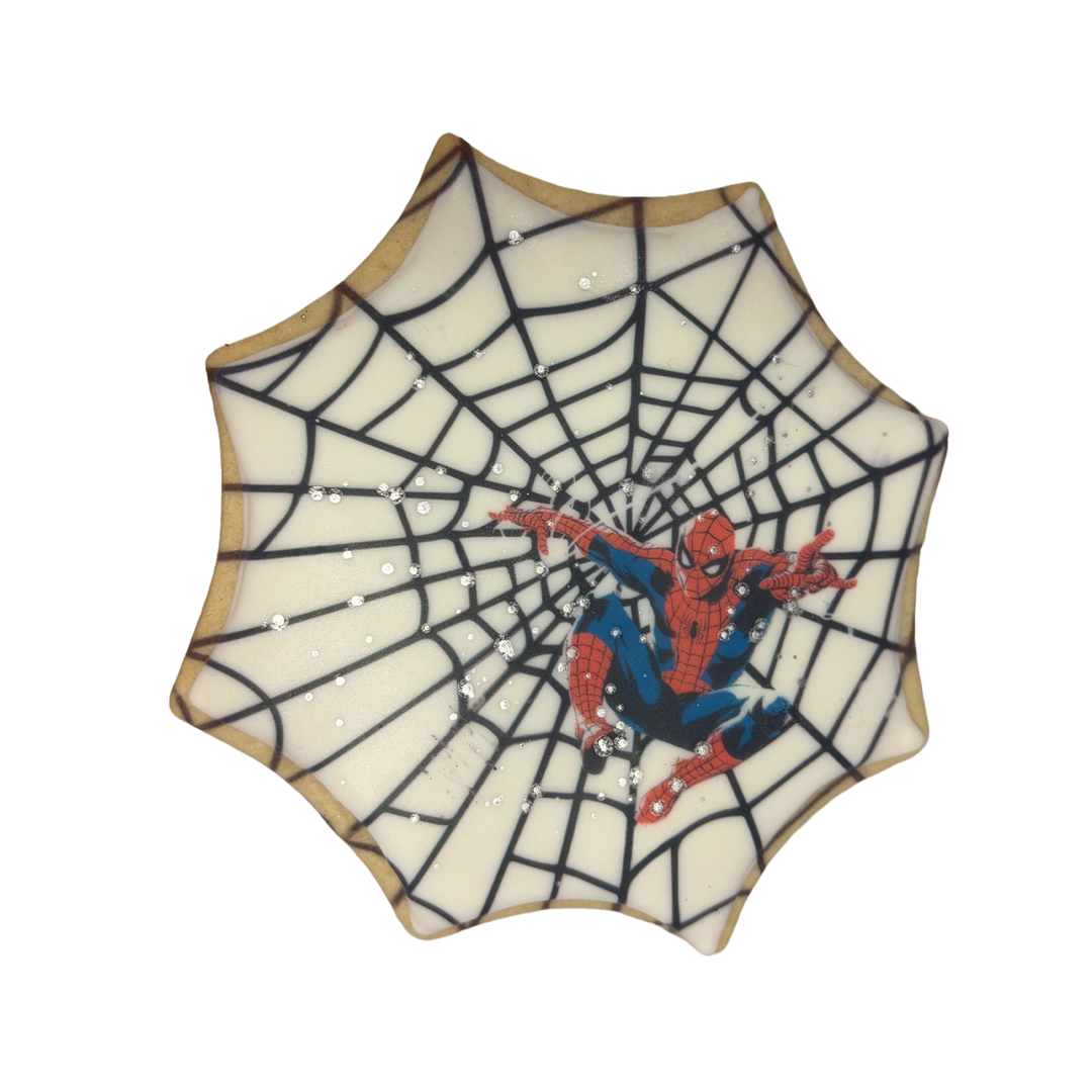Spiderman cookie with white icing and black web design.