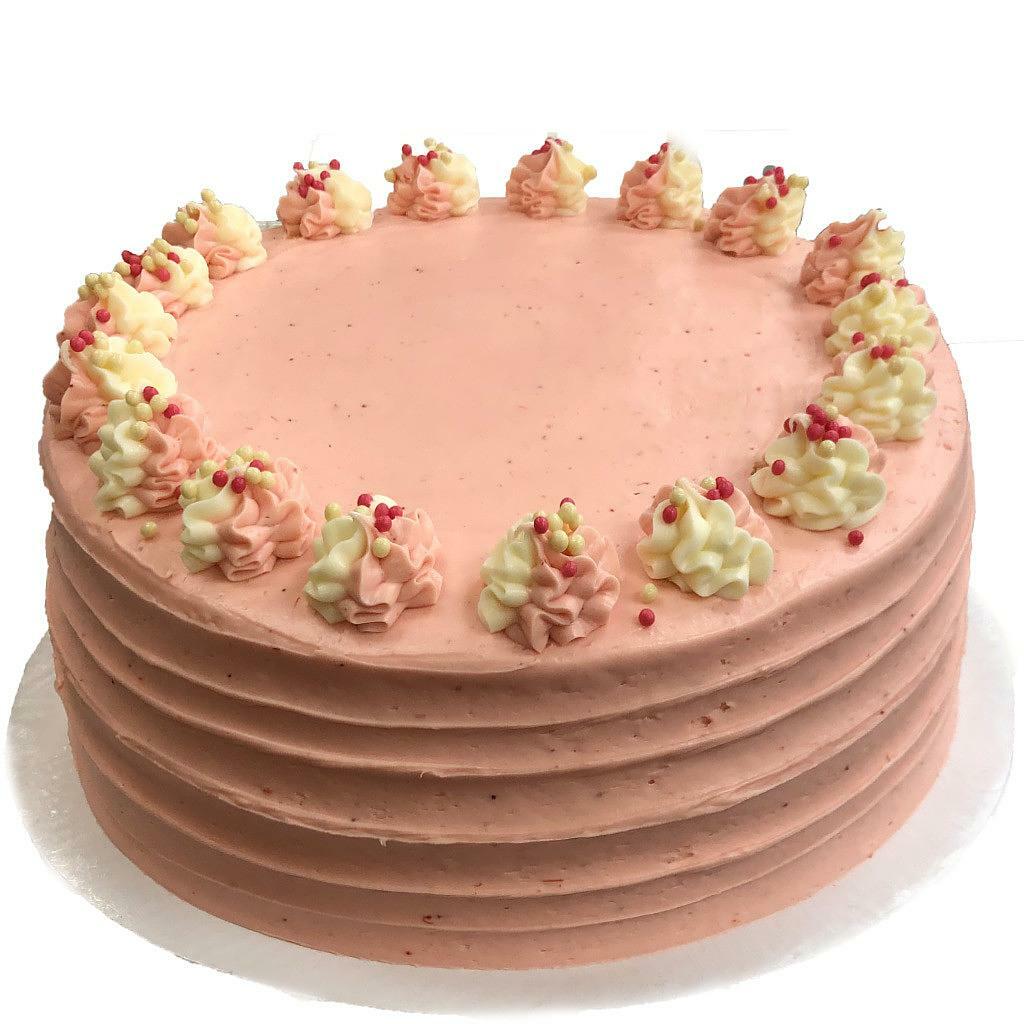 Strawberry Dream round cake with pink frosting and piped swirls