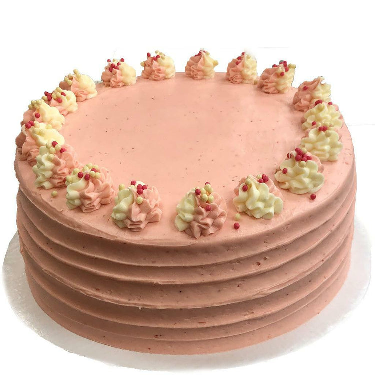 Strawberry Dream round cake with pink frosting and piped swirls