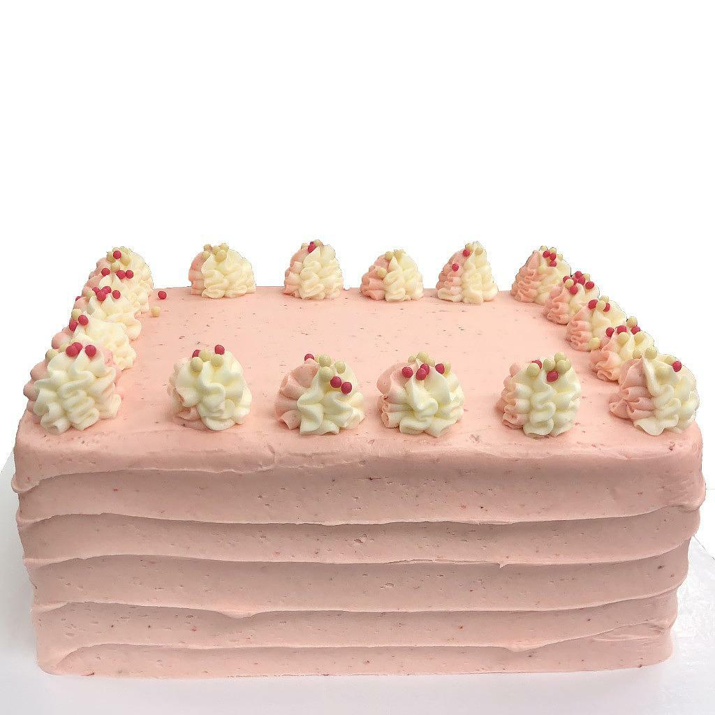 Strawberry Dream sheet cake with pink frosting and piped rosettes.