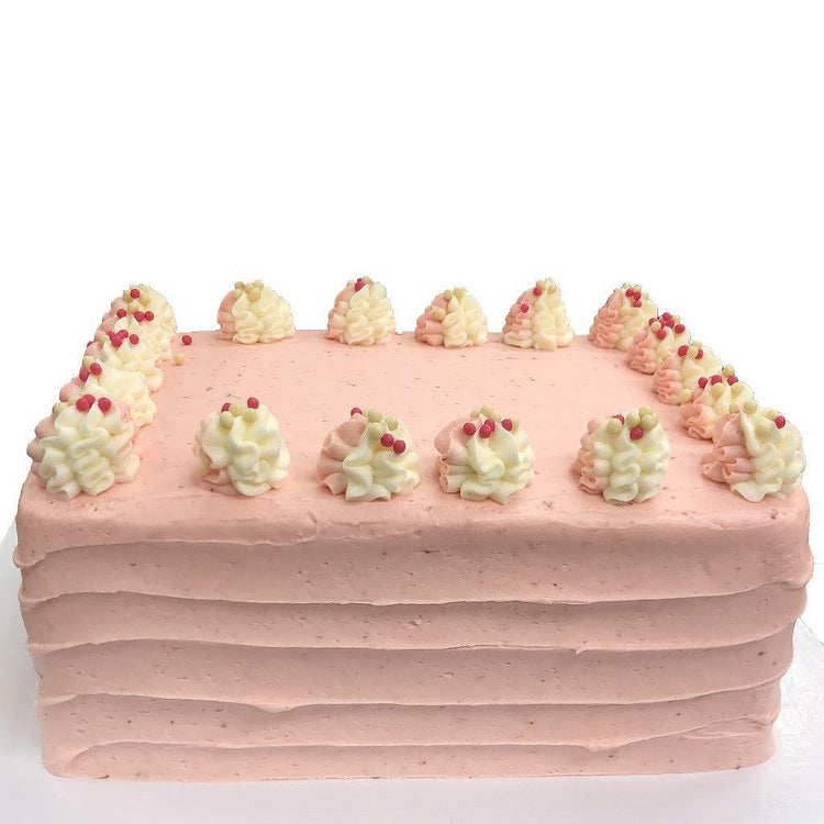 Strawberry Dream sheet cake with pink frosting and piped rosettes.