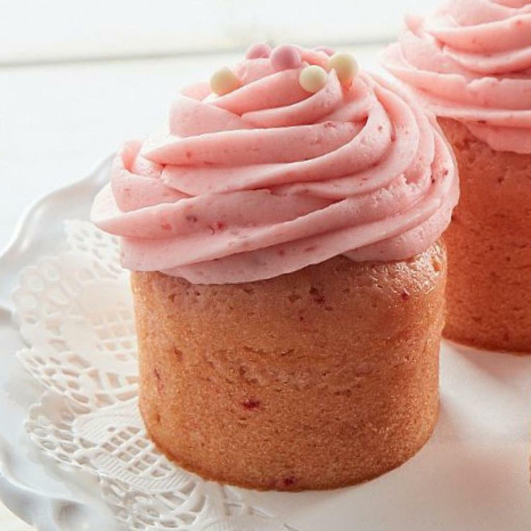 Assorted cupcakes with pink frosting on a white doily.